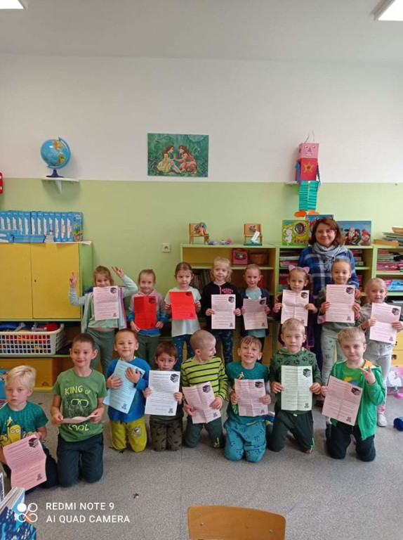 Dzieci z klasy O B z listami do rodziców i z bibliotekarzem