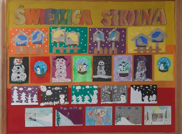 Tablica - żółto-pomarańczowo-czerwone tło, kolorowy napis 'Świetlica szkolna', prace uczniów związane z zimą.
