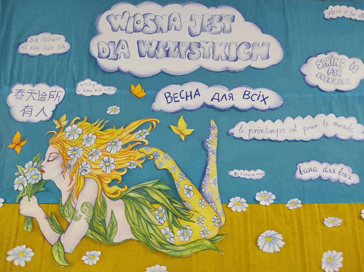 niebieskie i zółte tło, w chmurkach fioletowe napisy, żółte motyle, białe kwiatki, leżąca postać wiosny.