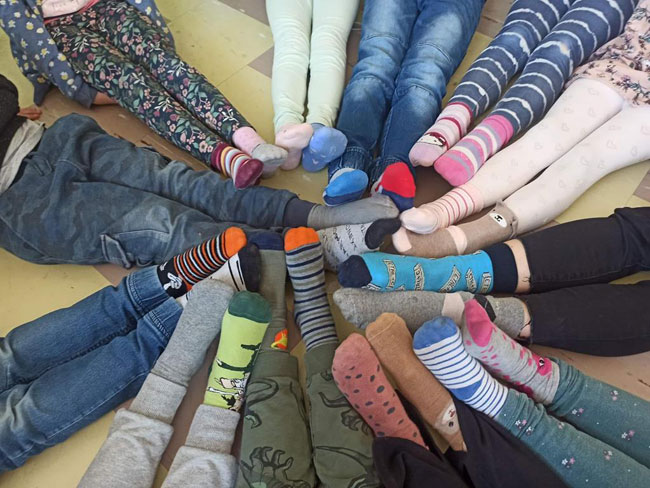 Nogi dzieci, na stopach kolorowe skarpetki.